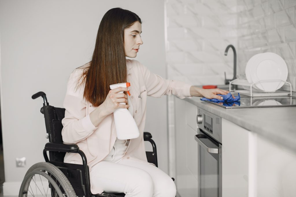 An image of a woman in wheelchair providing home cleaning services.